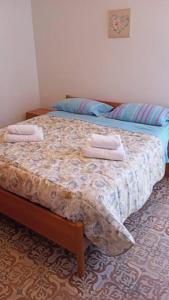 a bedroom with a bed with two towels on it at appartamento Walter in centro in Rosolina Mare