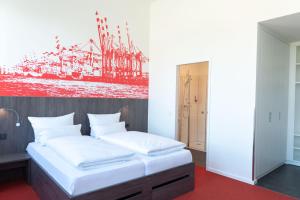 a bedroom with a bed with a painting on the wall at havenhostel Bremerhaven in Bremerhaven