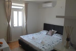 een slaapkamer met een bed met twee kommen erop bij Sun Studio Apartment in Komolac