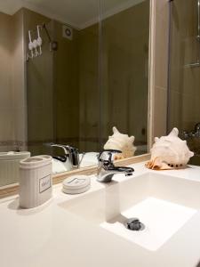 eine Badezimmertheke mit einem Waschbecken und einem Spiegel in der Unterkunft Oasis club apartments in Lozenets