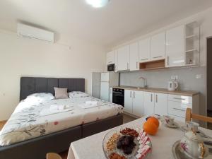 een slaapkamer met een bed en een tafel met een bord eten bij Sun Studio Apartment in Komolac