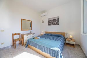 a bedroom with a bed and a mirror and a chair at Aethalia - a 300mt dal mare in Marina di Campo