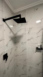 a shower with white marble walls and a ceiling at Stylish Executive Apartment with Power Backup in Johannesburg