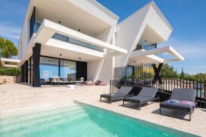 ein Haus mit einem Pool vor einem Haus in der Unterkunft Luxury Villa Ole with Pool in Kostrena