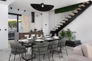 ein Esszimmer mit einem Tisch, Stühlen und einer Treppe in der Unterkunft Luxury Villa Ole with Pool in Kostrena
