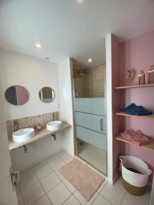 a bathroom with two sinks and a shower at Chez Flo et Manon in Balleroy