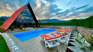 a swimming pool with lounge chairs and a house at villa hidden paradise garden in Fethiye