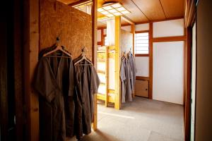 une chambre avec des cintres sur le mur dans un bâtiment dans l'établissement 長瀞NEMAKI, à Nogami