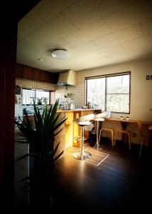 a kitchen with a counter and a table and chairs at 長瀞NEMAKI in Nogami