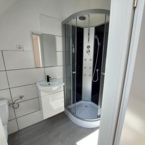 a bathroom with a shower and a toilet and a sink at Hotel 24 in Bilstein
