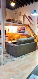 ein Wohnzimmer mit einem Sofa und einer Treppe in der Unterkunft Loft-Duplex Centro City in Montilla