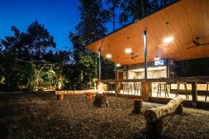 un bâtiment avec bancs devant lui la nuit dans l'établissement Daydream Lodge, à Tampaksiring