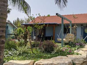 una casa con un columpio en un jardín en Provence in the Valley, en Kefar Barukh