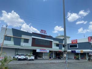 a building with cars parked in front of it at Hotel Staywell,Pithampur in Akolia