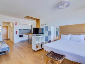 a bedroom with a large bed and a living room at AL - Be Happy Apartment in Vilamoura