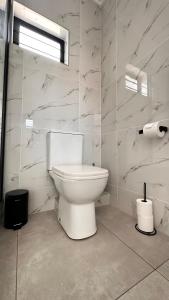a bathroom with a white toilet in a room at Stylish Executive Apartment with Power Backup in Johannesburg