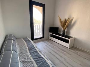 een slaapkamer met een bed, een dressoir en een raam bij Appartement Port Leucate, 2 pièces, 4 personnes - FR-1-81-43 in Port Leucate