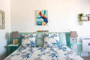 - une chambre avec un lit doté d'oreillers bleus et blancs dans l'établissement Bibifoc Baie - au coeur de la Baie de la Somme, à Saint-Valery-sur-Somme