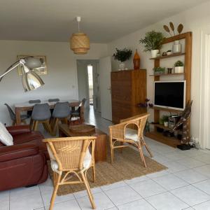 uma sala de estar com um sofá e uma mesa em Les Salinières em La Baule