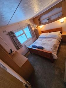Un dormitorio con una cama grande y una ventana en Cozy rural lodge, amazing views close to Holmfirth, en Holmfirth