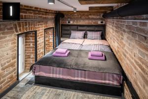um quarto com uma cama numa parede de tijolos em The Heart of Lviv Apartments - Lviv em Lviv