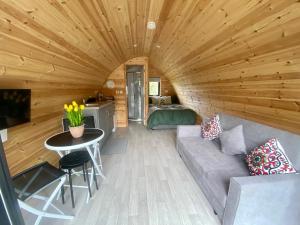 a living room of a log cabin with a couch and a table at Glamping at Share Discovery Village in Lisnaskea