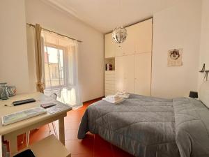 una camera da letto con un letto, una scrivania e una finestra di B&B Frori ad Alghero