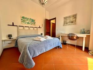 una camera da letto con un letto con una coperta blu e un tavolo di B&B Frori ad Alghero