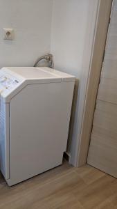um frigorífico branco ao lado de um lavatório num quarto em Mountain Summer Houses - River Sound em Panagia