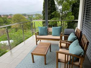 a porch with two benches and a table on a balcony at Comfy Apartment Bojnice in Bojnice