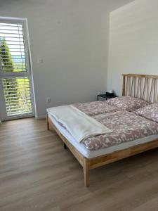 a bedroom with a bed and a large window at Comfy Apartment Bojnice in Bojnice