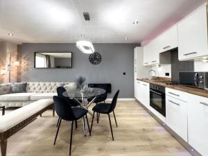 a kitchen and living room with a table and chairs at Central Leeds Penthouse in Leeds
