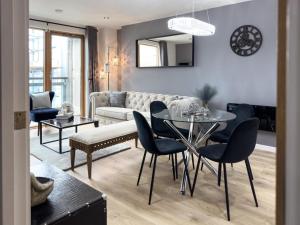 Central Leeds Penthouse في ليدز: غرفة معيشة مع طاولة وكراسي وأريكة