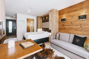 pokój hotelowy z łóżkiem i kanapą w obiekcie AvenidA Mountain Lodges Kaprun w Kaprunie