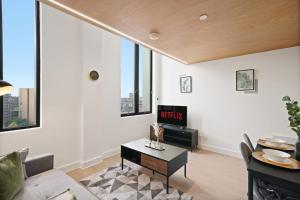 a living room with a couch and a table at Skygardens - Stylish Central Duplex - Roof Garden in Manchester