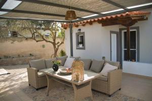 a patio with a couch and a table at Xanthi's Summer House in Vathí