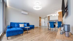 sala de estar con sofá azul y mesa en Apartamenty Sun & Snow Na Klifie, en Władysławowo
