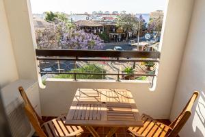 una mesa y sillas en un balcón con vistas en Cozy Albufeira Charm, en Albufeira