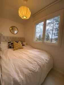 a bedroom with a large white bed with a window at Modern cottage in Årsta Havsbad Stockholm, Sweden in Årsta Havsbad