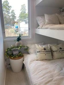 Årsta Havsbad的住宿－Modern cottage in Årsta Havsbad Stockholm, Sweden，一间卧室,配有一张带窗户和植物的床
