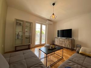 ein Wohnzimmer mit einem Sofa und einem TV in der Unterkunft Apartement ANCICA in Split