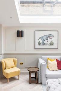 a living room with a dinosaur picture on the wall at ALTIDO Spectacular house with private garden in London