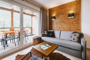 AvenidA Mountain Lodges Kaprun في كابرون: غرفة معيشة مع أريكة وطاولة