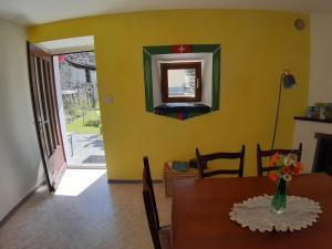 a dining room with a table and a mirror on the wall at Casa Allegra- appartamento Calla in Cavergno