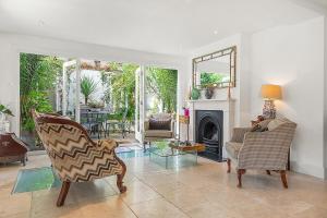 a living room with two chairs and a fireplace at Veeve - Heart of Hampstead in London