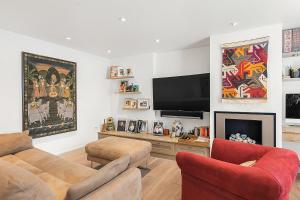 a living room with a couch and a flat screen tv at Veeve - Heart of Hampstead in London