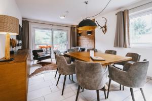 jadalnia z drewnianym stołem i krzesłami w obiekcie AvenidA Mountain Lodges Kaprun w Kaprunie