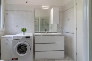 a white bathroom with a washing machine and a sink at Fiera di Ferrara Huge Apartment x7! in Ferrara