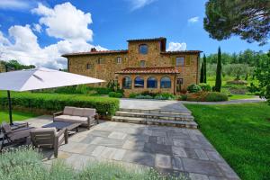 a house with a patio and an umbrella at Villa Bellostare by PosarelliVillas in Cantagrillo