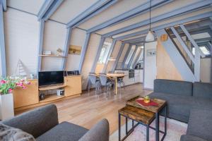 ein Wohnzimmer mit einer Couch und einem Tisch in der Unterkunft Ferienwohnpark Immenstaad am Bodensee Nurdachhaus Typ 7 ND 40 in Immenstaad am Bodensee